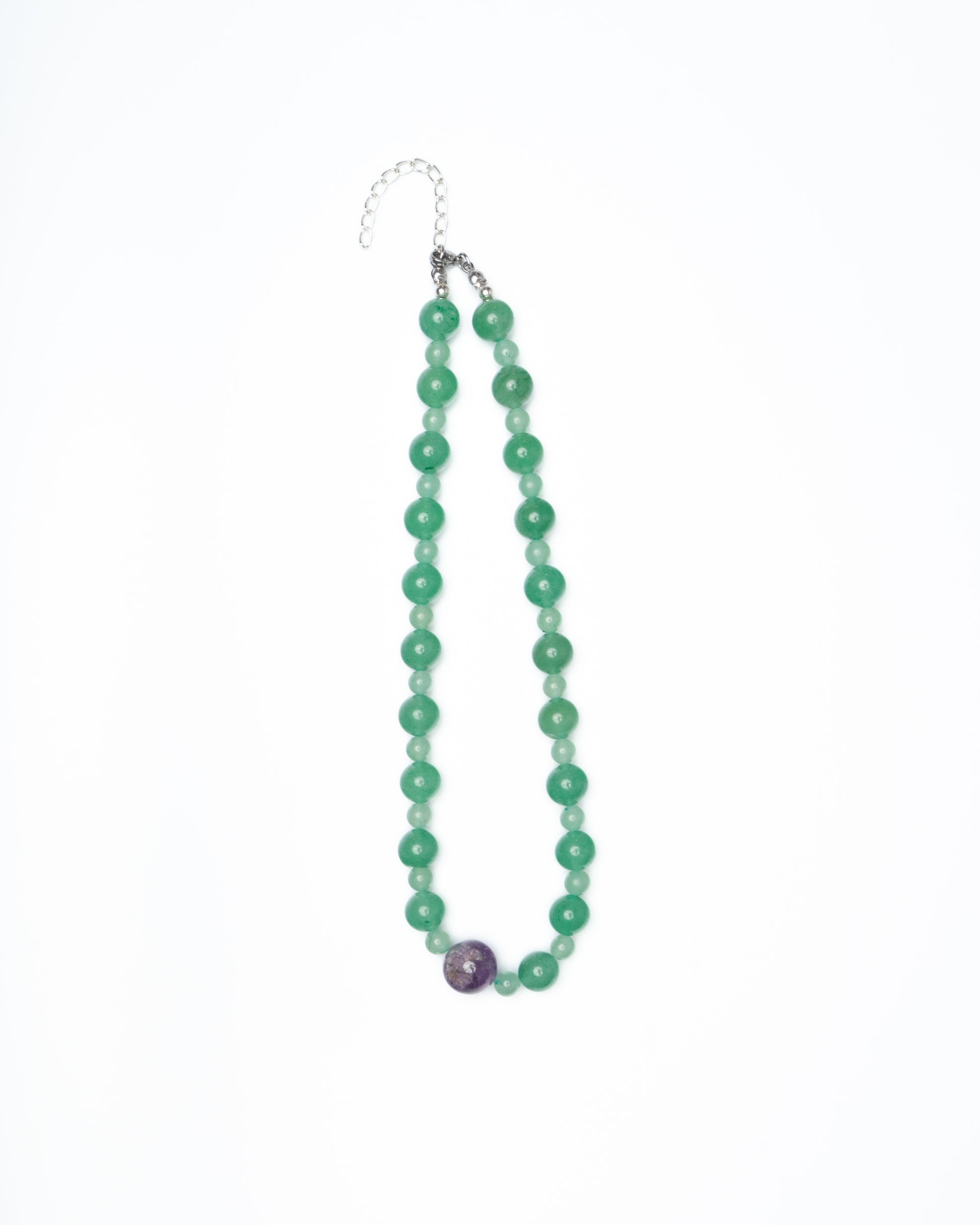 Green beaded necklace with a purple bead on a white background