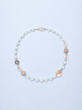 Necklace with pearls and shell-like beads on a light blue background